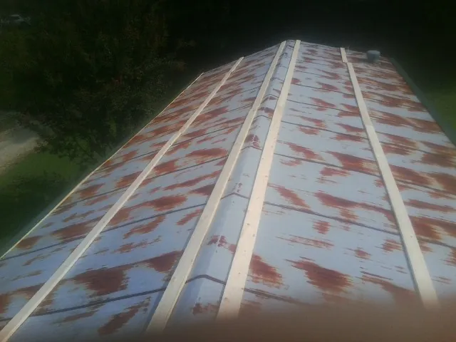 Rusted metal roof panels with new wood purlins before replacement — Storm Damage Roof Repair in Lenox Dale by Roofing Brothers