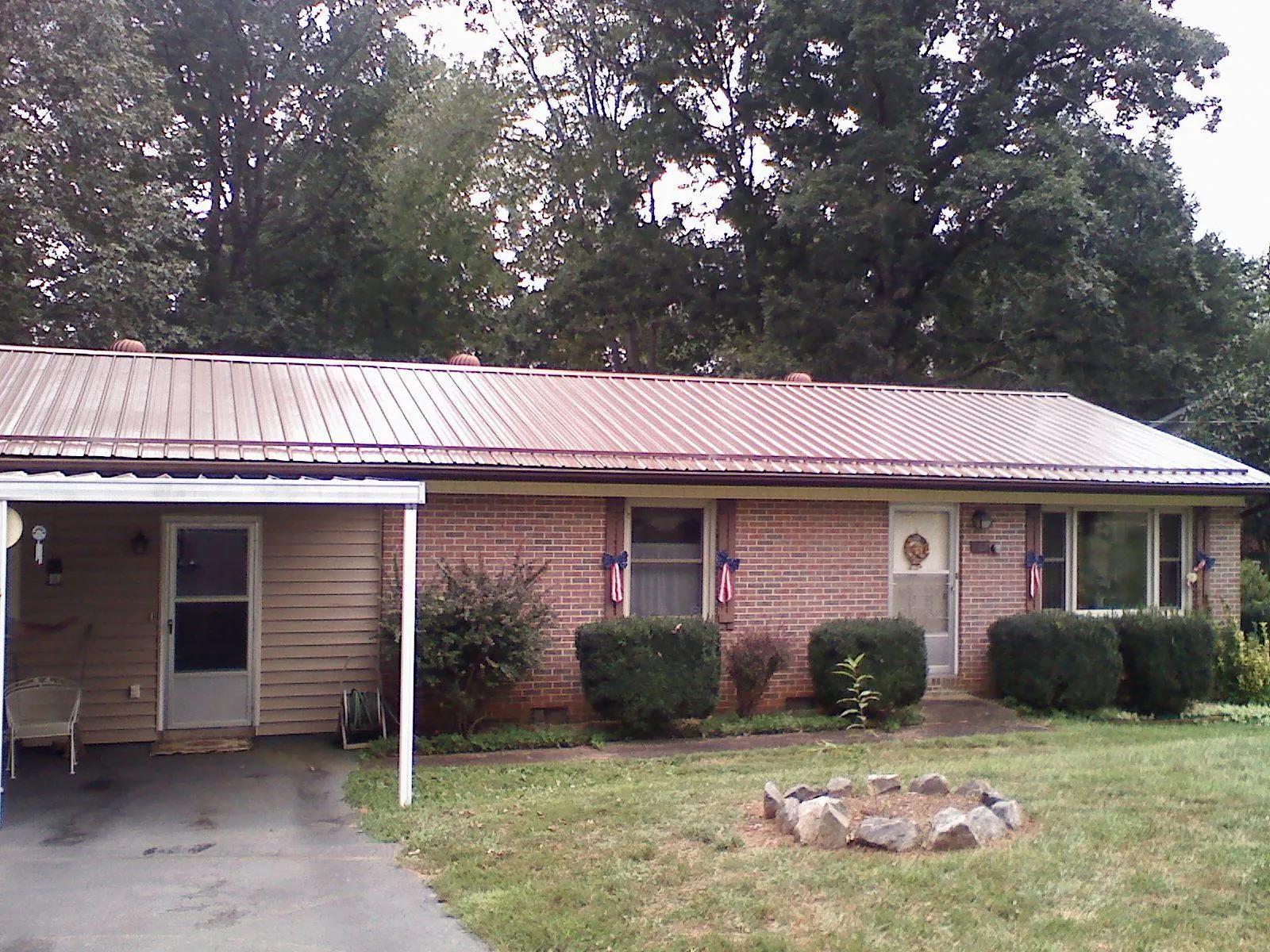 Bronze metal roof and carport on a brick ranch home — Roof Repair work by our crew in Lenox Dale